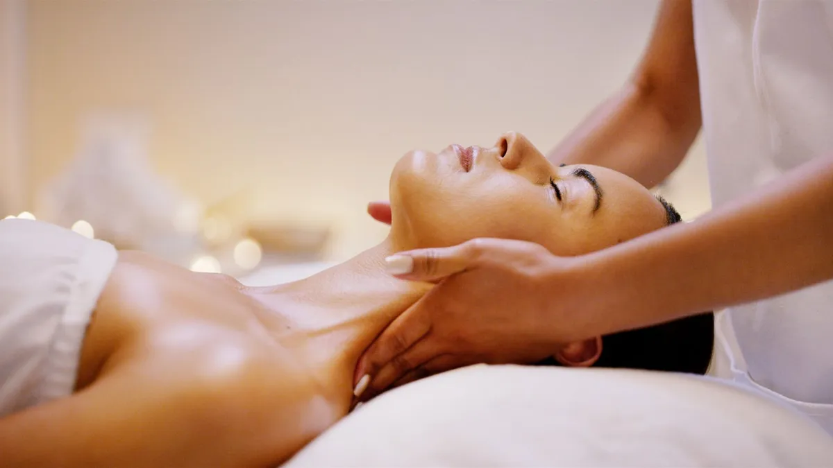 An esthetician performing a facial treatment on a relaxed guest